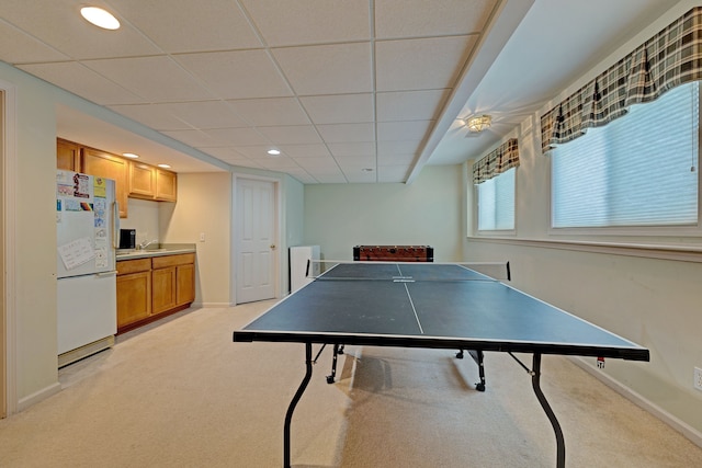 rec room with a paneled ceiling and light colored carpet