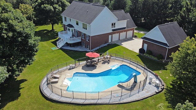 view of swimming pool featuring a lawn, a patio area, and a water slide