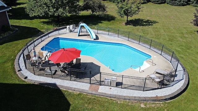 view of swimming pool with a lawn, a patio, and a water slide