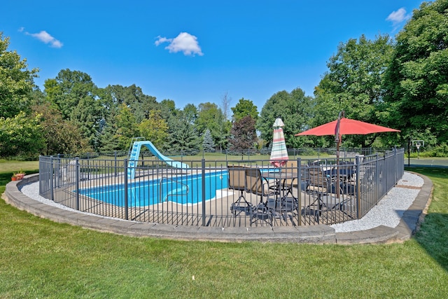 view of pool with a lawn, a patio area, and a water slide