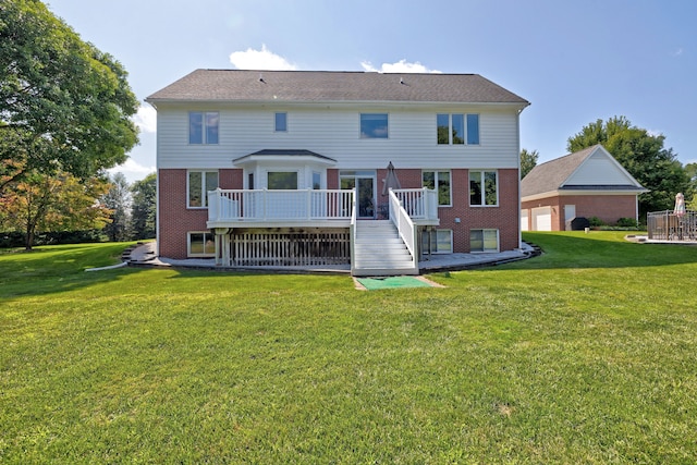 back of property with a wooden deck and a yard