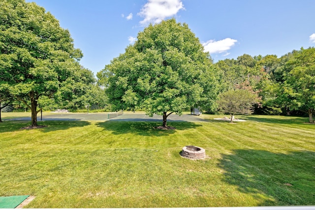 view of property's community featuring a fire pit and a lawn