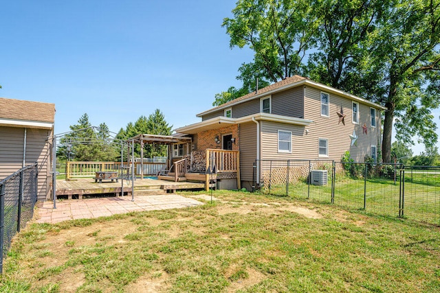 back of property featuring a lawn, a wooden deck, and central AC