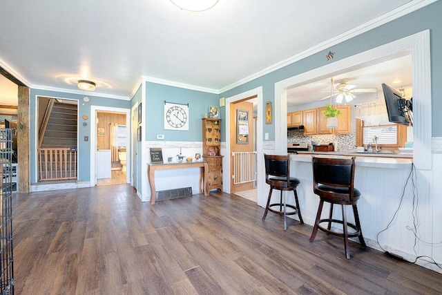 2370 S M-140, Eau Claire, MI 49111 - kitchen featuring light brown cabinetry, a kitchen breakfast bar, decorative backsplash, dark wood finished floors, and ornamental molding