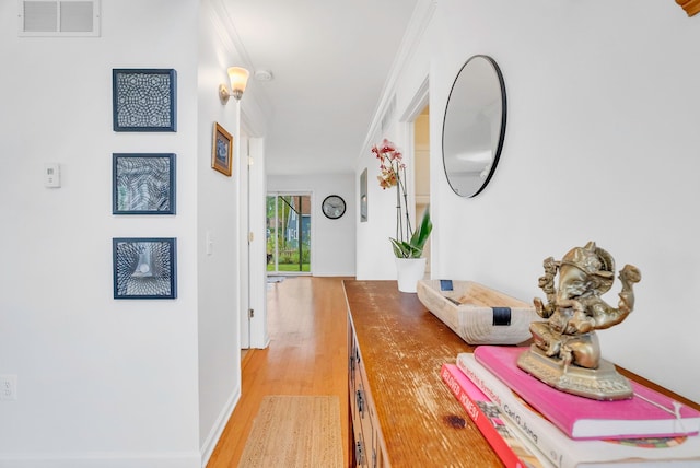 corridor with crown molding and light hardwood / wood-style flooring