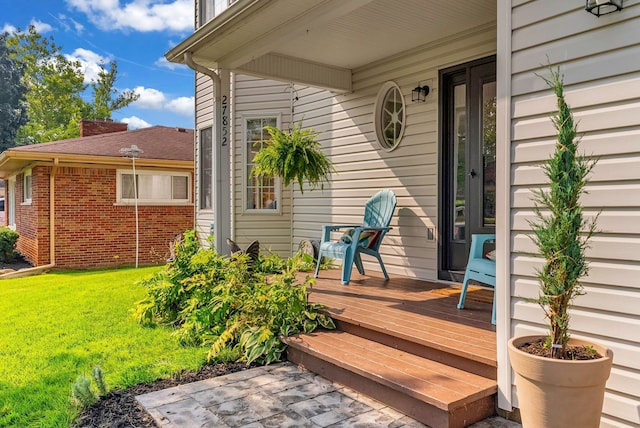 wooden terrace featuring a lawn