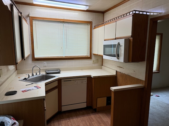 kitchen with white cabinetry, sink, tasteful backsplash, white appliances, and hardwood / wood-style flooring