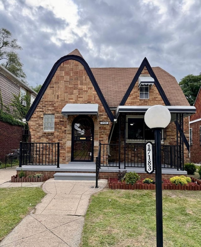 tudor home featuring a front yard and a porch