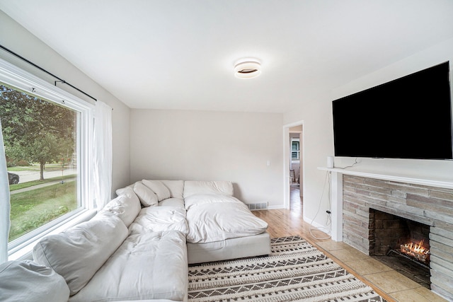 living room with light tile patterned floors and a brick fireplace