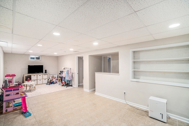 recreation room featuring a paneled ceiling and built in features