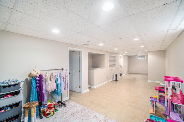 rec room featuring a paneled ceiling, built in features, and light tile patterned flooring