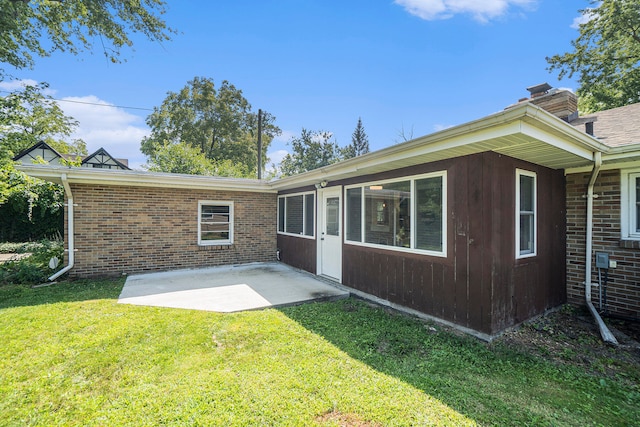 back of house with a patio area and a lawn