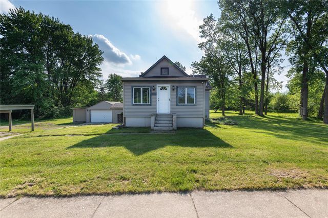 view of front of home featuring an outbuilding, a garage, and a front lawn