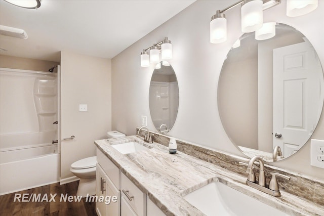 full bathroom featuring hardwood / wood-style floors, vanity, shower / bath combination, and toilet