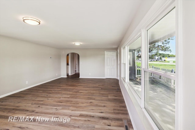 empty room with dark hardwood / wood-style flooring