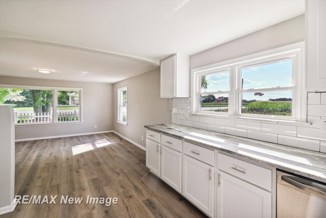 kitchen featuring white cabinets, light stone countertops, a wealth of natural light, and tasteful backsplash