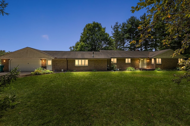 ranch-style home with a garage and a yard