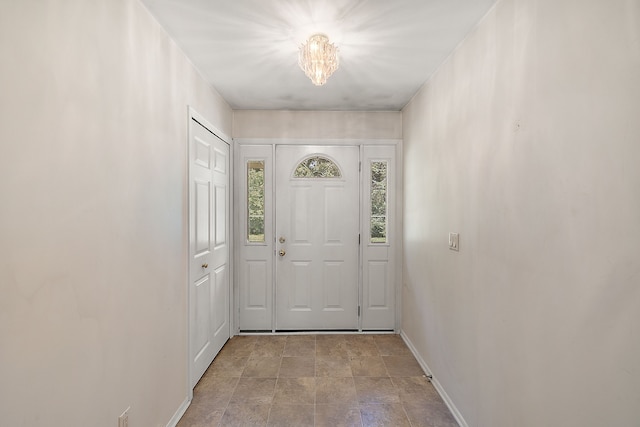 doorway to outside with a notable chandelier