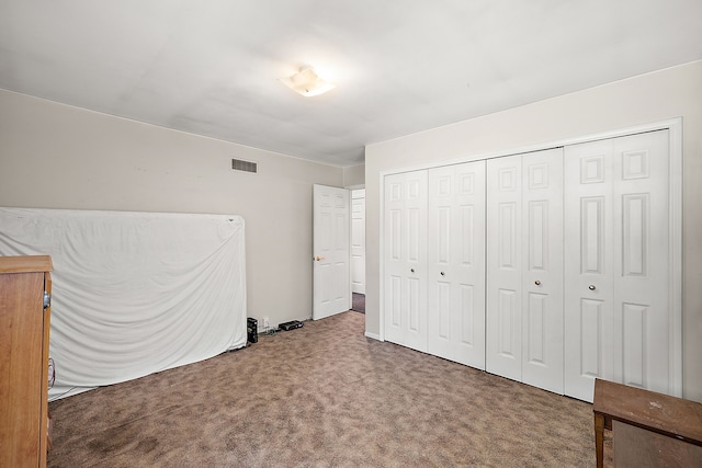 unfurnished bedroom with dark carpet and a closet