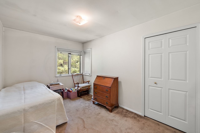 bedroom with light colored carpet and a closet