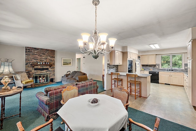 dining area featuring sink, a fireplace, and an inviting chandelier