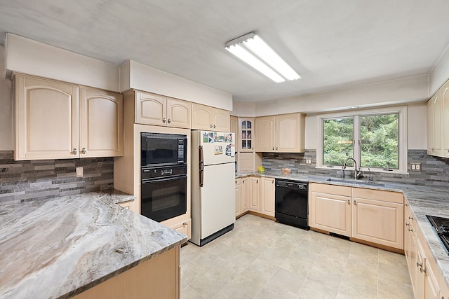 kitchen featuring light stone countertops, sink, light brown cabinets, decorative backsplash, and black appliances