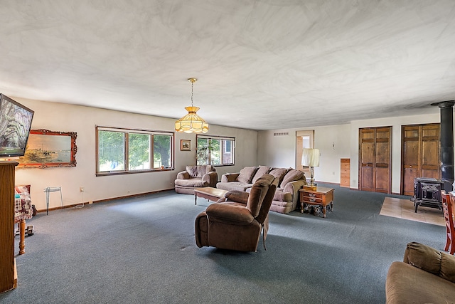 carpeted living room with a wood stove