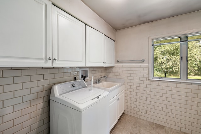 washroom featuring cabinets, washer / dryer, sink, and tile walls