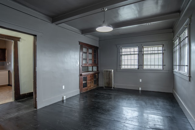 unfurnished room featuring beam ceiling, radiator, crown molding, and dark hardwood / wood-style flooring