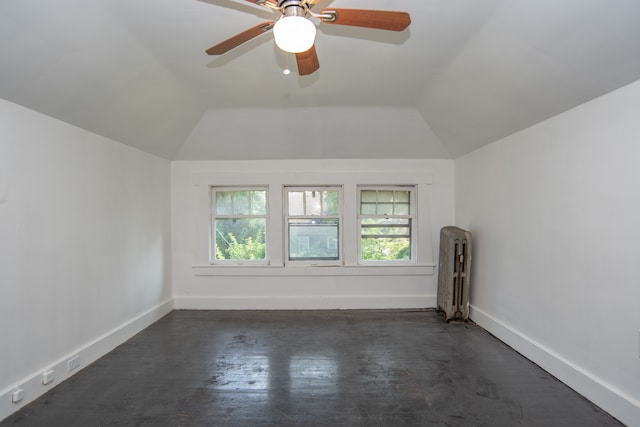 unfurnished room with radiator heating unit, vaulted ceiling, ceiling fan, and dark wood-type flooring