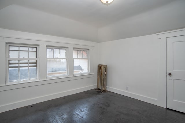 unfurnished room with radiator and dark wood-type flooring