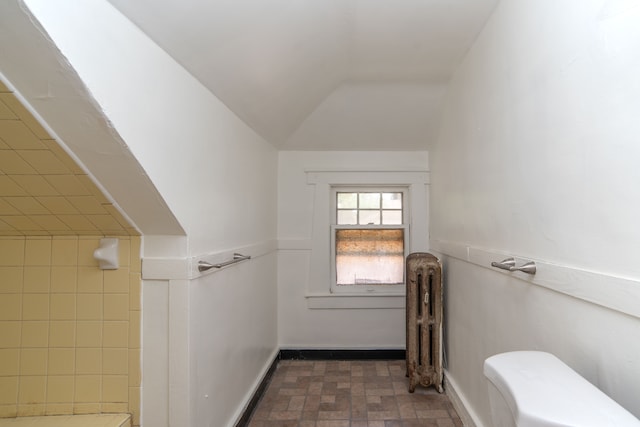 bathroom with radiator, lofted ceiling, and toilet