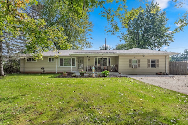 rear view of property featuring a yard and covered porch