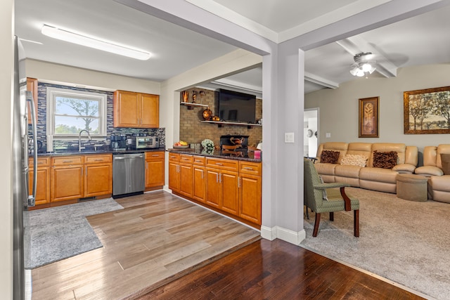 kitchen with backsplash, ceiling fan, light hardwood / wood-style flooring, and stainless steel appliances