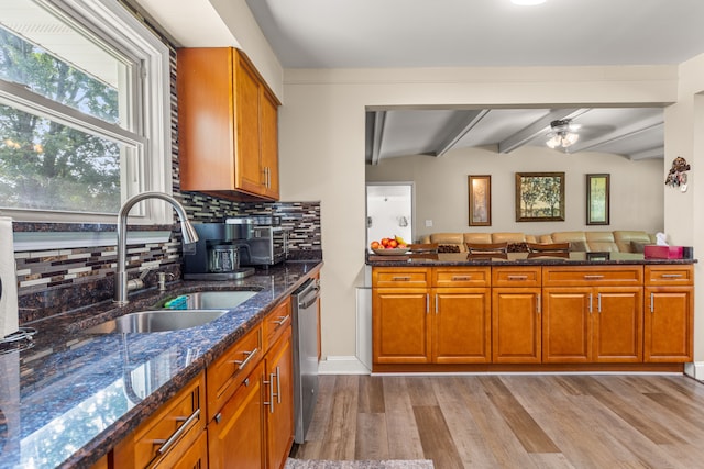 kitchen with backsplash, sink, lofted ceiling with beams, dishwasher, and light hardwood / wood-style floors