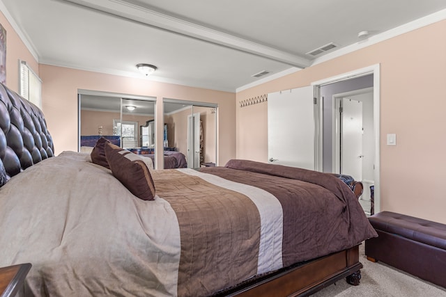 bedroom with carpet flooring, two closets, beam ceiling, and ornamental molding