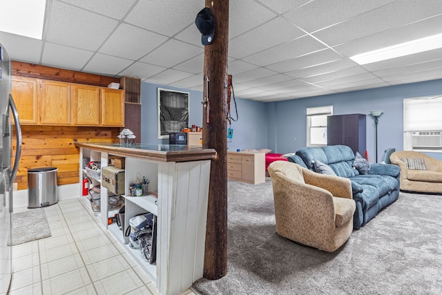 living room with a paneled ceiling, cooling unit, and wood walls