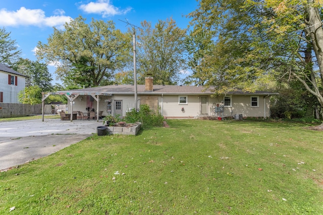 back of house featuring a patio area and a lawn