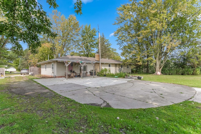 rear view of house featuring a patio area and a lawn