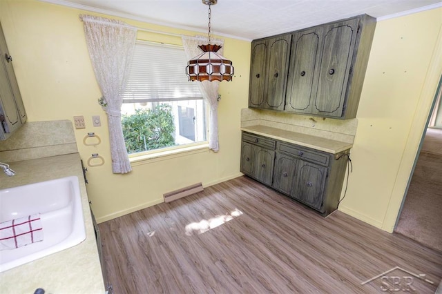 kitchen featuring crown molding, sink, and light hardwood / wood-style floors