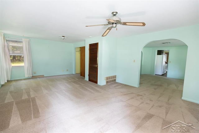 unfurnished room with light colored carpet and ceiling fan