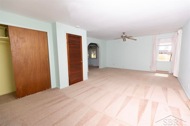 interior space with ceiling fan and light carpet