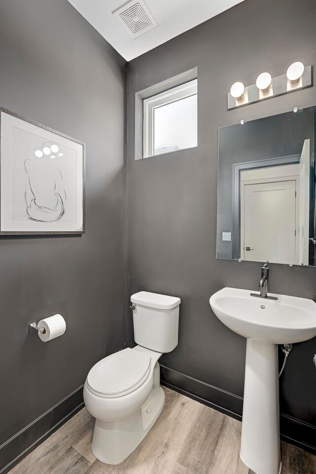 bathroom with sink, hardwood / wood-style floors, and toilet