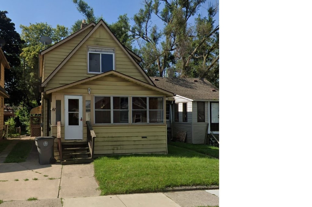 bungalow-style home with a front yard