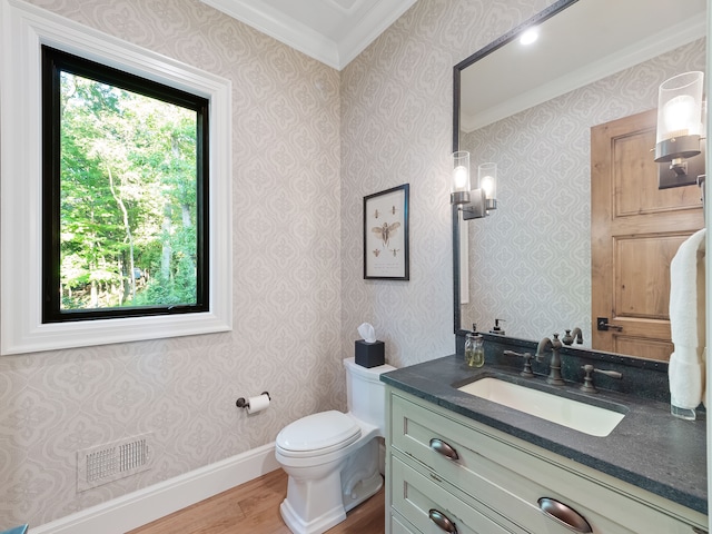 bathroom featuring hardwood / wood-style flooring, vanity, toilet, and crown molding