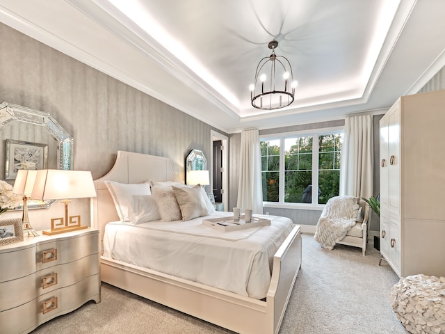 carpeted bedroom with a tray ceiling and an inviting chandelier