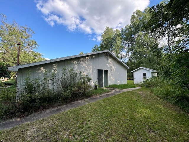back of property featuring a yard and a storage unit