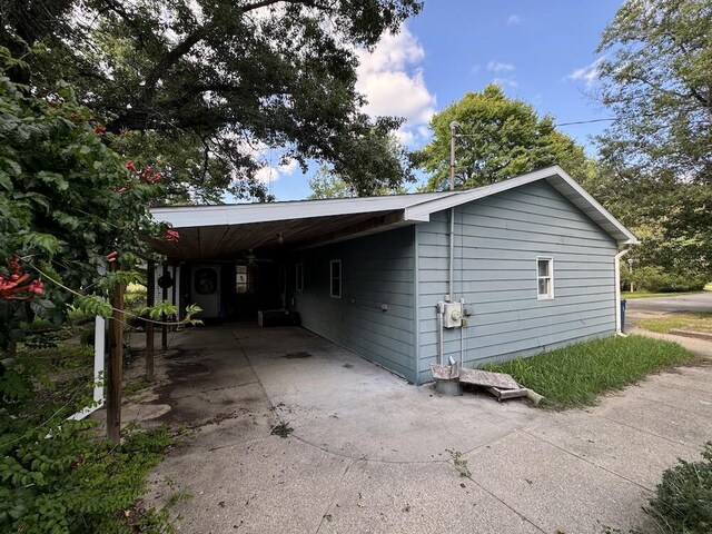 5490 S Harrison Rd, Houghton Lake, MI 48629 - view of side of property featuring concrete driveway and a carport
