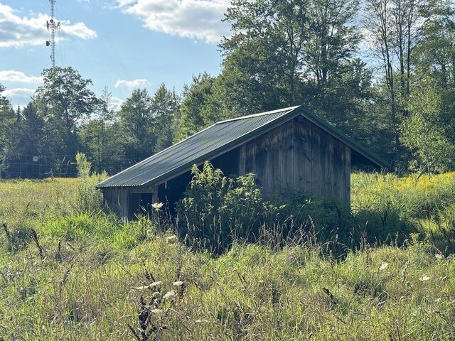 5490 S Harrison Rd, Houghton Lake, MI 48629 - view of outdoor structure featuring a wooded view