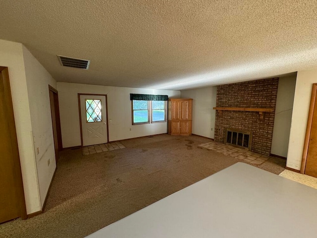 unfurnished living room with a textured ceiling, light carpet, and a brick fireplace